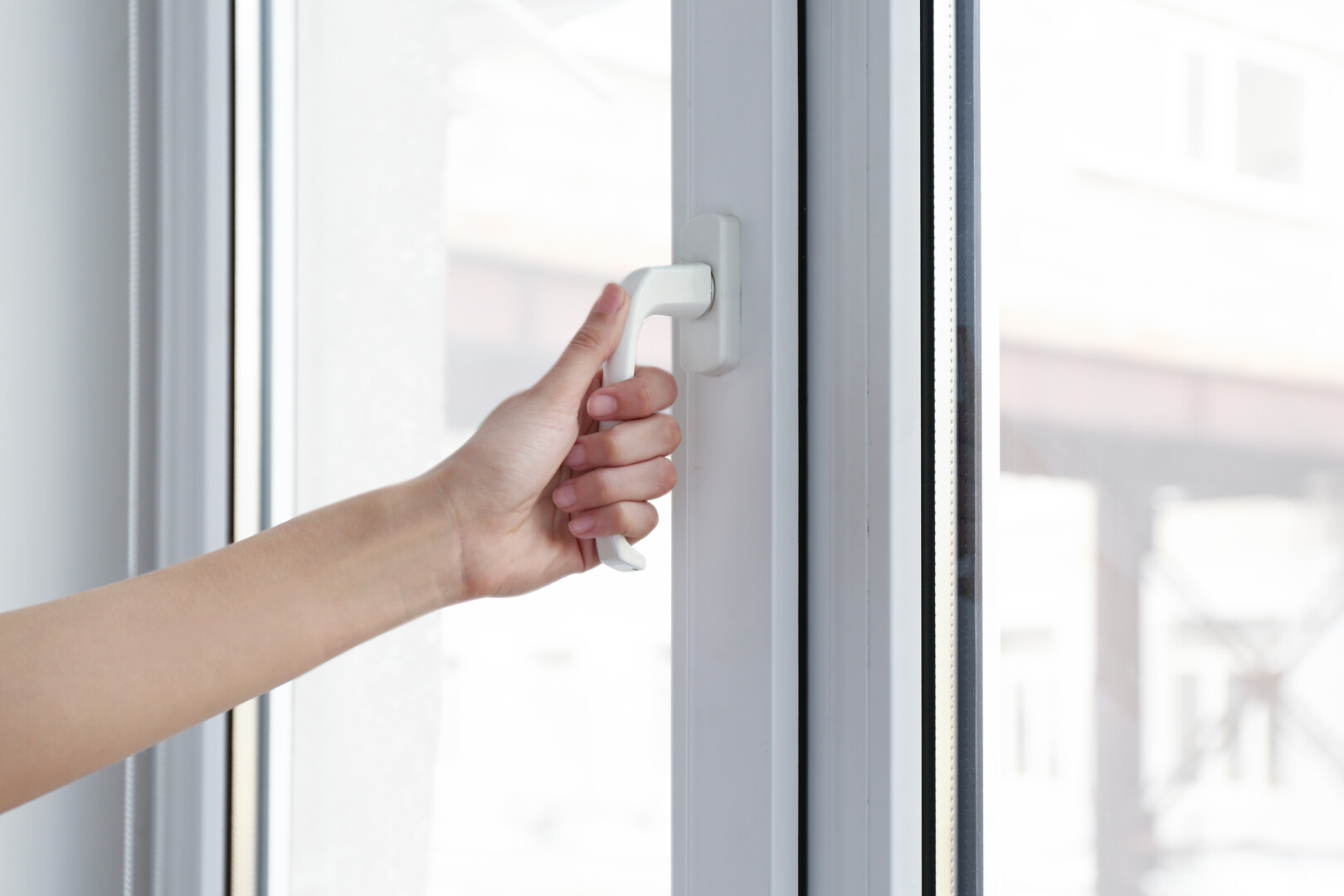 Young woman opening window in flat